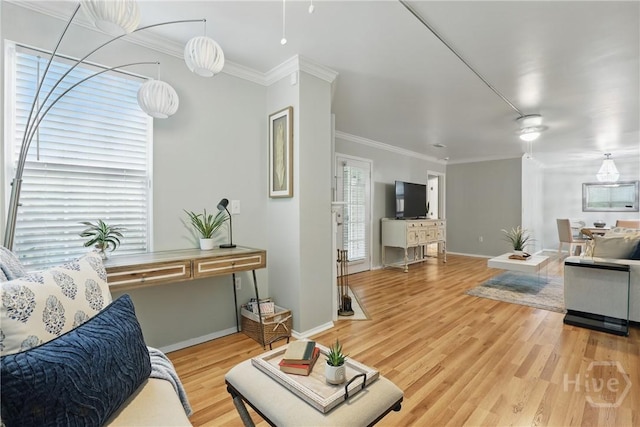 living room with crown molding, light wood finished floors, and baseboards