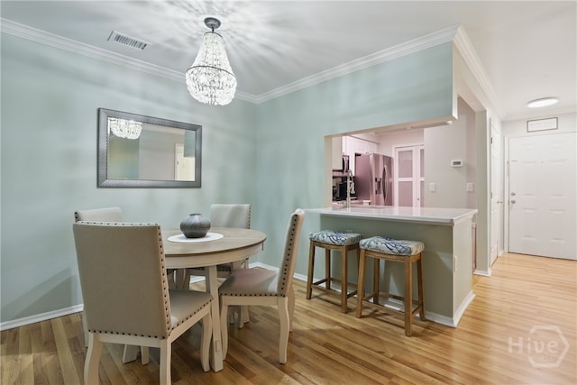 12300 Apache Ave Unit 1716, Savannah, GA 31419 - dining space with baseboards, a chandelier, crown molding, and light wood-style flooring