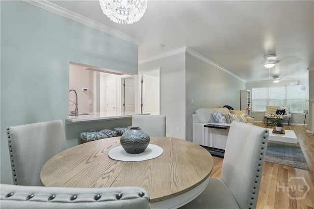 dining space with wood finished floors, crown molding, and a chandelier