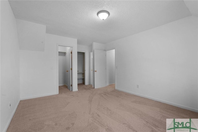 539 Pointe S Dr, Savannah, GA 31410 - unfurnished bedroom featuring carpet, a textured ceiling, baseboards, and a walk in closet