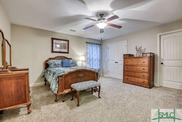 carpeted bedroom featuring baseboards, a ceiling fan, a closet, and a textured ceiling