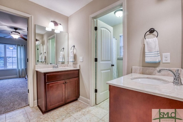 bathroom with two vanities, baseboards, and a ceiling fan