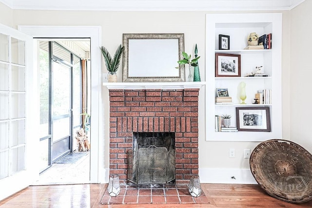 2206 E 39th St, Savannah, GA 31404 - living area featuring crown molding, wood finished floors, built in shelves, and a brick fireplace
