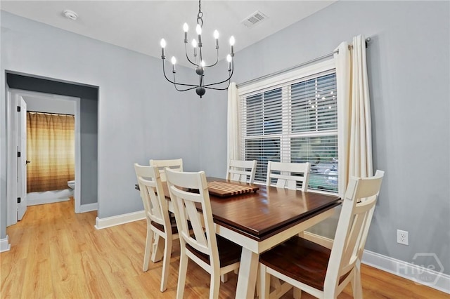 dining room with a chandelier, light wood-style floors, and baseboards
