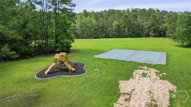 view of grassy yard with a forest view