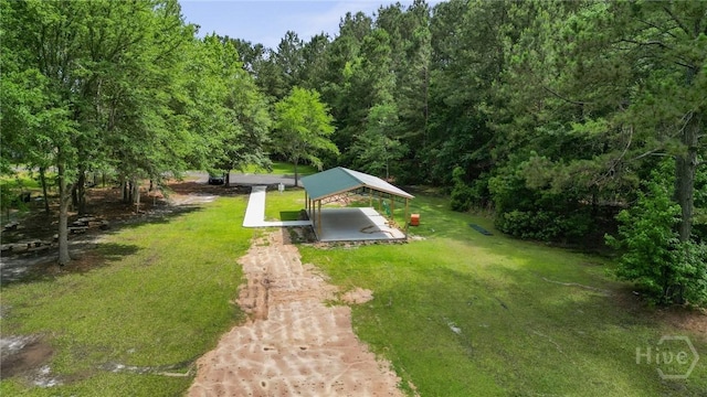 view of green lawn with a gazebo, dirt driveway, and a detached carport
