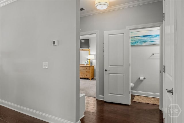 hall featuring ornamental molding, baseboards, and dark wood-type flooring