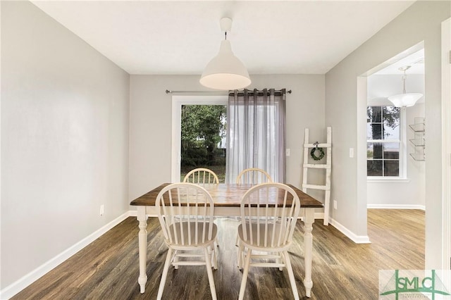dining room with dark wood-style flooring and baseboards