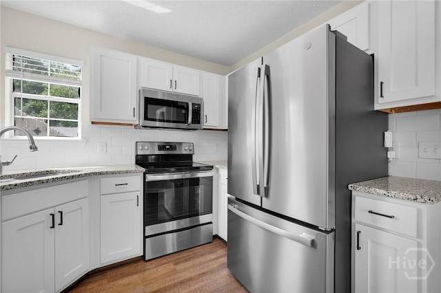 2 Mclaughlin Ct, Savannah, GA 31419 - kitchen featuring stainless steel appliances, a sink, white cabinets, decorative backsplash, and light stone countertops