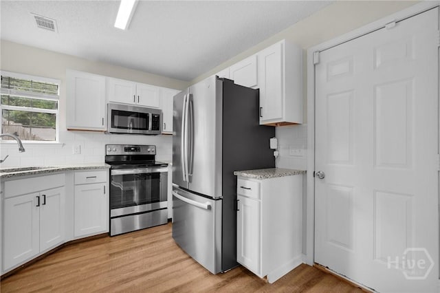 2 Mclaughlin Ct, Savannah, GA 31419 - kitchen with appliances with stainless steel finishes, a sink, light wood-type flooring, and white cabinets