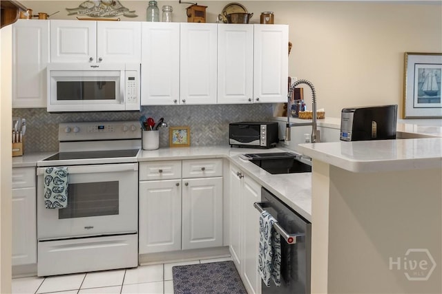 3 3rd St Unit 538, Tybee Island, GA 31328 - kitchen featuring white appliances, white cabinetry, light tile patterned flooring, and backsplash