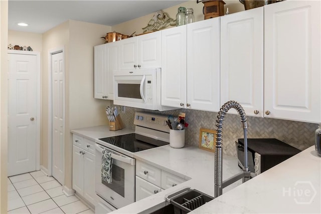 3 3rd St Unit 538, Tybee Island, GA 31328 - kitchen with white appliances, light tile patterned flooring, white cabinetry, and recessed lighting