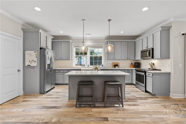 kitchen featuring appliances with stainless steel finishes, gray cabinets, crown molding, light countertops, and recessed lighting