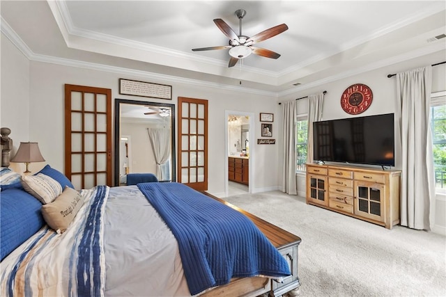 bedroom featuring a tray ceiling, multiple windows, carpet, and ornamental molding
