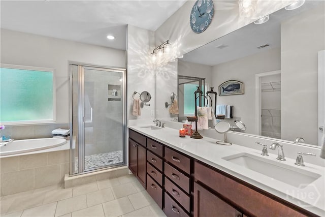 bathroom featuring a shower stall, tile patterned flooring, a garden tub, double vanity, and a walk in closet