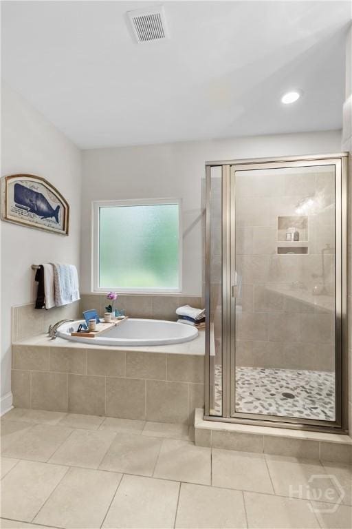 bathroom featuring a garden tub, a stall shower, and tile patterned floors