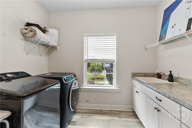 laundry area featuring light wood-style flooring, washer and dryer, baseboards, and cabinet space