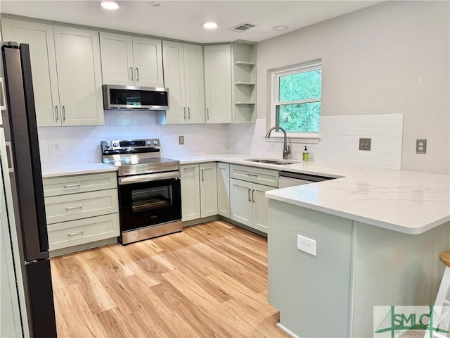 932 Millstream Ct, Savannah, GA 31419 - kitchen featuring appliances with stainless steel finishes, a sink, a peninsula, light wood-style flooring, and backsplash