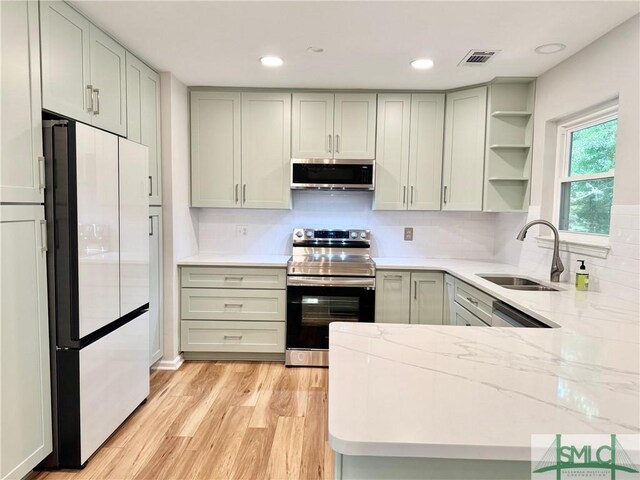 932 Millstream Ct, Savannah, GA 31419 - kitchen featuring appliances with stainless steel finishes, a sink, light wood finished floors, tasteful backsplash, and open shelves