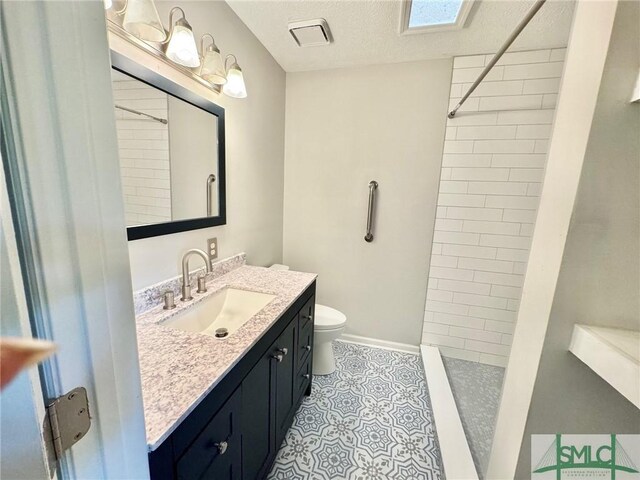 932 Millstream Ct, Savannah, GA 31419 - full bath with a tile shower, toilet, vanity, tile patterned flooring, and a textured ceiling