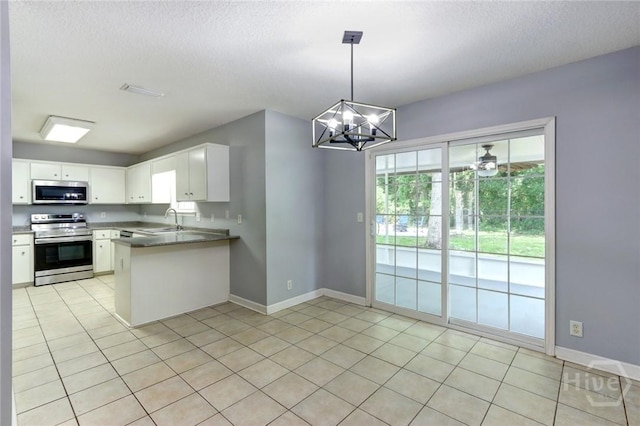 30 Bridgewater Way, Brunswick, GA 31525 - kitchen with stainless steel appliances, a sink, a chandelier, a peninsula, and white cabinets
