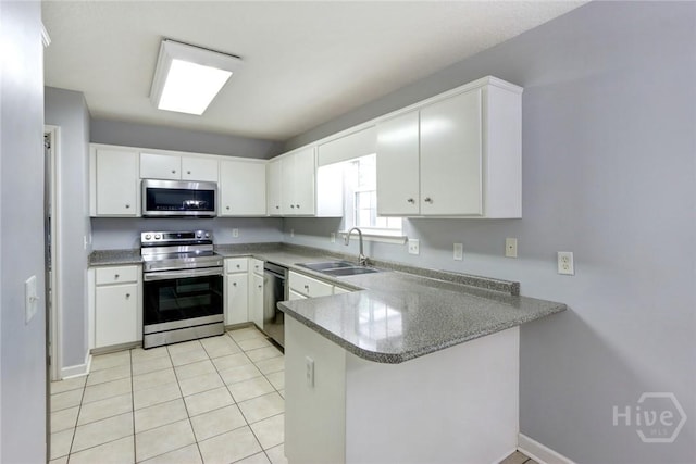 30 Bridgewater Way, Brunswick, GA 31525 - kitchen with stainless steel appliances, a sink, a peninsula, white cabinets, and light tile patterned floors