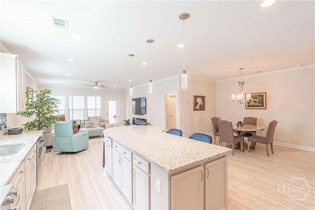137 Harvest Hl, Pooler, GA 31322 - kitchen featuring a center island, a sink, light wood-type flooring, a chandelier, and crown molding