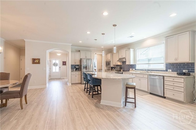 137 Harvest Hl, Pooler, GA 31322 - kitchen featuring appliances with stainless steel finishes, a kitchen breakfast bar, ornamental molding, under cabinet range hood, and decorative backsplash