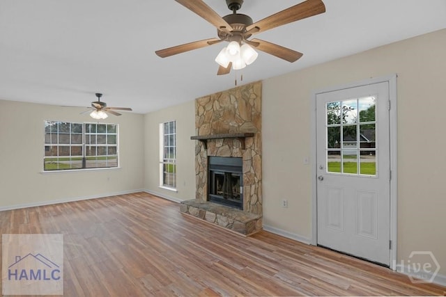1021 Bacon Rd, Hinesville, GA 31313 - unfurnished living room featuring light wood-style floors, ceiling fan, a fireplace, and baseboards