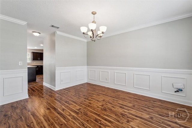 1107 Creekside Cir, Hinesville, GA 31313 - unfurnished room featuring a chandelier, dark wood-style flooring, ornamental molding, wainscoting, and a decorative wall