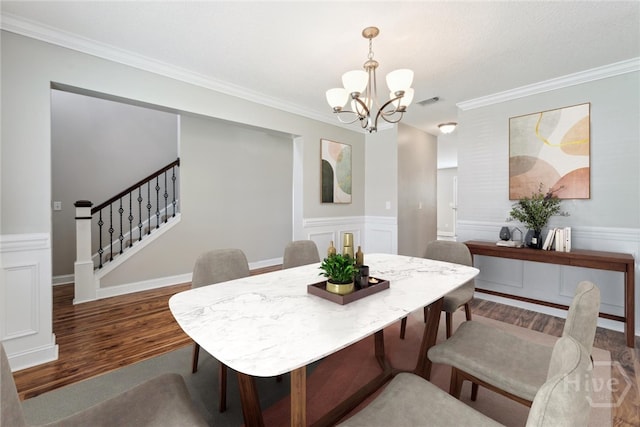1107 Creekside Cir, Hinesville, GA 31313 - dining area with wood finished floors, a chandelier, ornamental molding, stairs, and a wainscoted wall