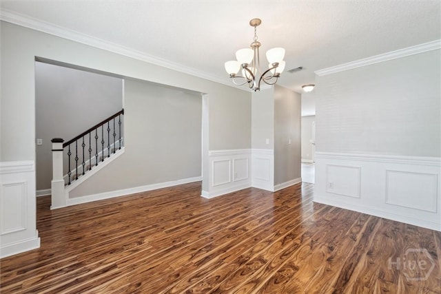 1107 Creekside Cir, Hinesville, GA 31313 - spare room with a chandelier, dark wood finished floors, a wainscoted wall, crown molding, and stairs