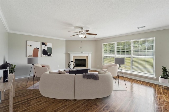 1107 Creekside Cir, Hinesville, GA 31313 - living area featuring a fireplace with raised hearth, ornamental molding, dark wood-style flooring, ceiling fan, and a textured ceiling