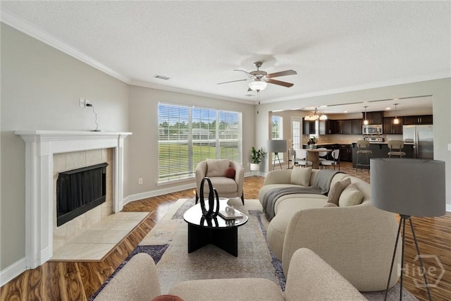 1107 Creekside Cir, Hinesville, GA 31313 - living room featuring baseboards, ornamental molding, light wood-style flooring, ceiling fan, and a tile fireplace