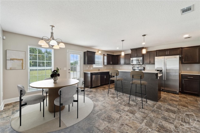 1107 Creekside Cir, Hinesville, GA 31313 - dining room with stone finish flooring, a chandelier, a textured ceiling, and baseboards