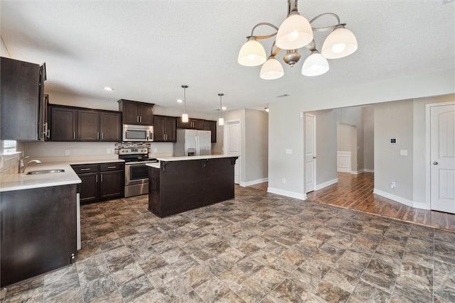1107 Creekside Cir, Hinesville, GA 31313 - kitchen with stainless steel appliances, a sink, dark brown cabinetry, a chandelier, and light countertops