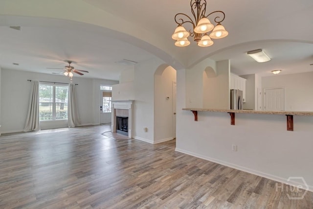 48 Chapel Lk N, Savannah, GA 31419 - unfurnished living room with ceiling fan, wood finished floors, baseboards, a tiled fireplace, and arched walkways