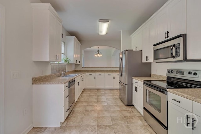 48 Chapel Lk N, Savannah, GA 31419 - kitchen featuring stainless steel appliances, arched walkways, a chandelier, light countertops, and white cabinets