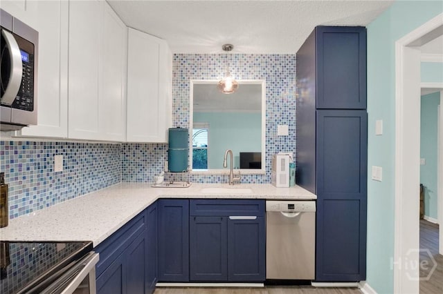 508 Pointe S Dr, Savannah, GA 31410 - kitchen with appliances with stainless steel finishes, tasteful backsplash, white cabinetry, light stone countertops, and pendant lighting