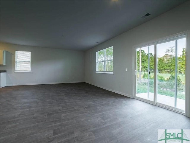 empty room featuring dark wood-style flooring and baseboards