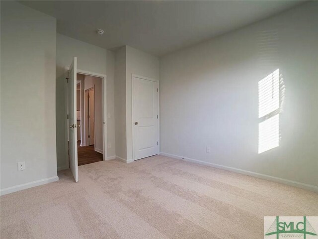 unfurnished bedroom with light carpet and baseboards