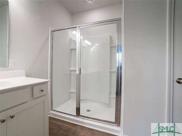 bathroom featuring a stall shower, vanity, and wood finished floors
