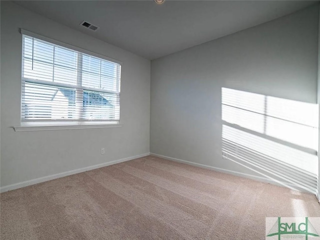 carpeted spare room featuring baseboards