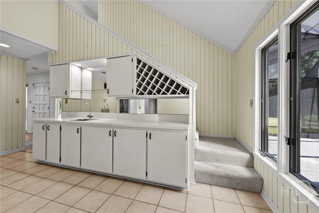 2402 Easy St, Savannah, GA 31406 - kitchen featuring light countertops, light tile patterned flooring, vaulted ceiling, a sink, and baseboards