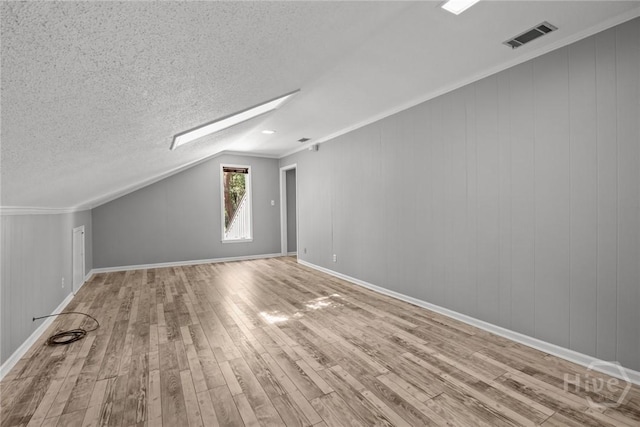 2402 Easy St, Savannah, GA 31406 - bonus room with wood finished floors, a skylight, lofted ceiling, baseboards, and a textured ceiling