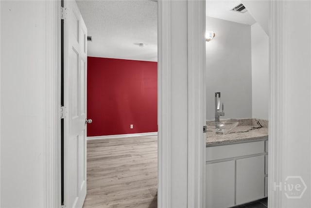 2402 Easy St, Savannah, GA 31406 - bathroom featuring wood finished floors, baseboards, vanity, and a textured ceiling