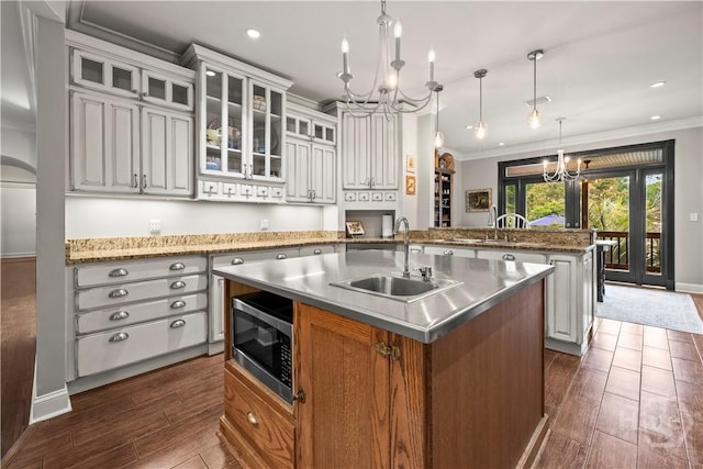 3309 Ga Highway 67, Pembroke, GA 31321 - kitchen featuring a chandelier, a sink, a center island with sink, stainless steel microwave, and dark wood-type flooring