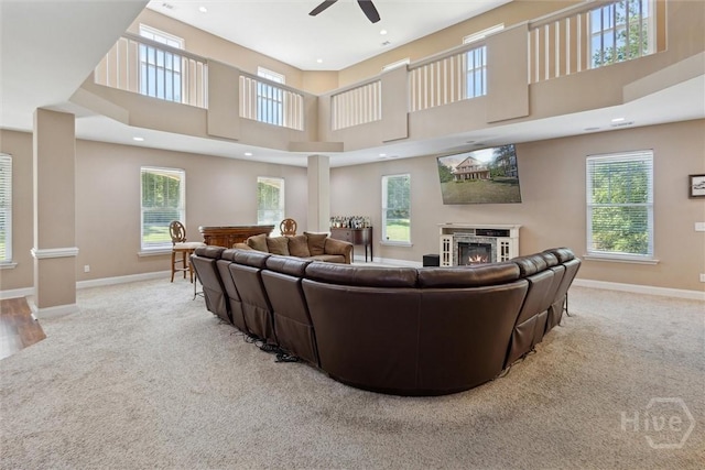 525 Elkins Cemetery Rd, Guyton, GA 31312 - carpeted living room with a warm lit fireplace, ceiling fan, baseboards, a towering ceiling, and recessed lighting