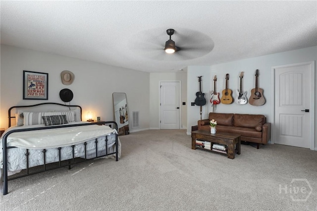 bedroom with carpet flooring, a ceiling fan, and a textured ceiling