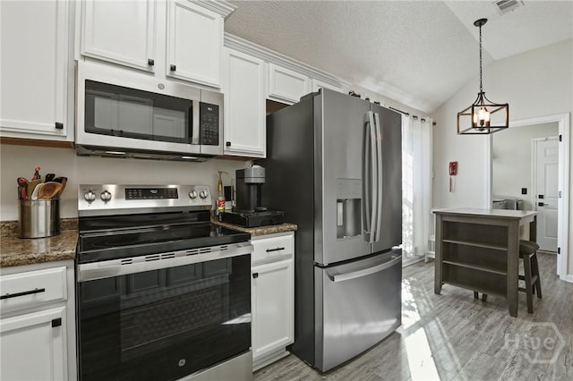 kitchen featuring appliances with stainless steel finishes, white cabinetry, lofted ceiling, light wood finished floors, and a textured ceiling